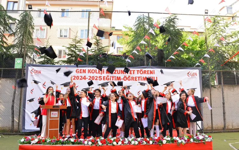 Açık havada düzenlenen mezuniyet töreninde kep atan öğrenciler